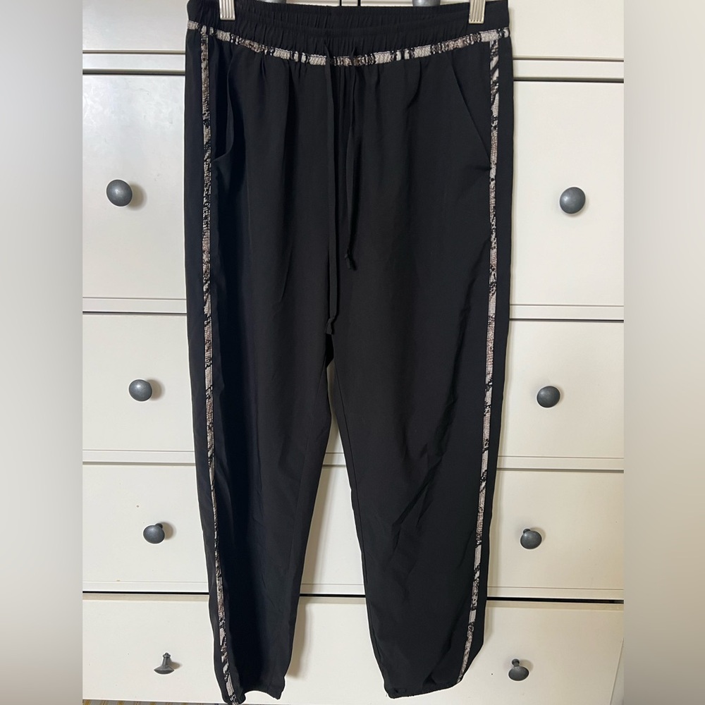 Allison Joy black joggers with snake pattern accents.